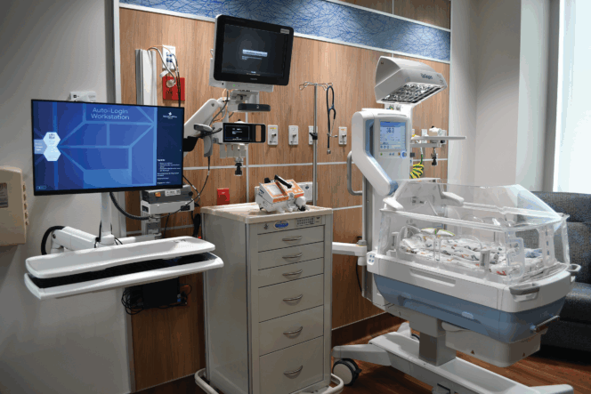 NICU station with an incubator, monitors, and medical equipment for newborn care.