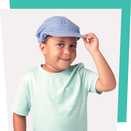 Smiling young Hispanic boy wearing a green shirt and train conductor's hat.
