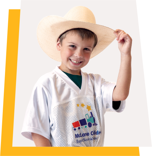 Young boy wearing a cowboy hat and McLane Children's football jersey