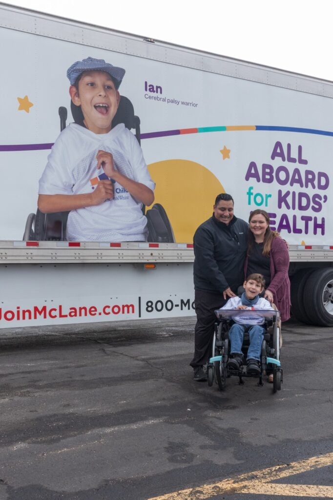 Ian poses with his parents in front of the trailer proudly featuring him as a train conductor. 

