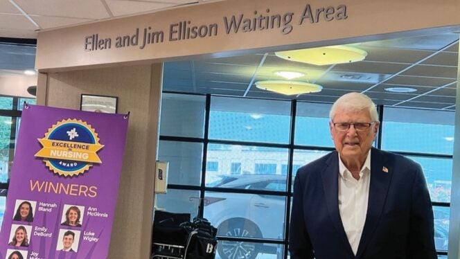 Sign reading “Ellen and Jim Ellison Waiting Area” inside a Baylor Scott & White facility, with a donor standing nearby and a nursing excellence award display in the background.
