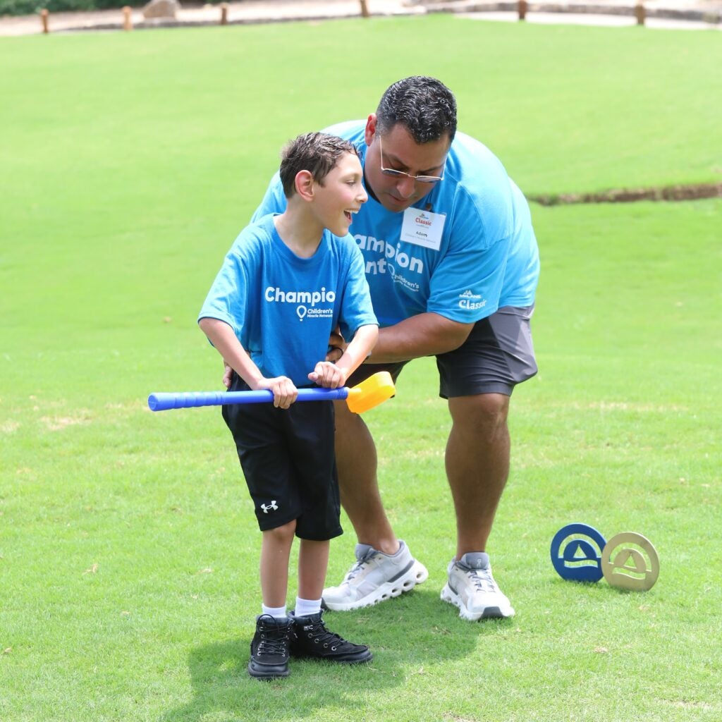 McLane Children's champion Ian puts with his own golf club with help from his dad.